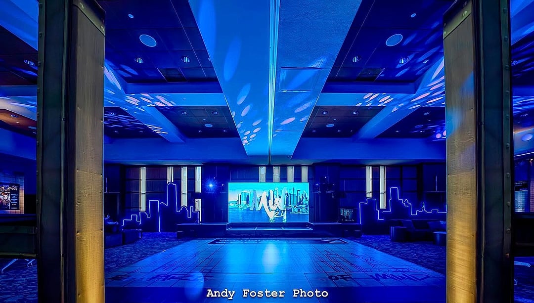 Ballroom dance floor framed by columns and a wide LED screen