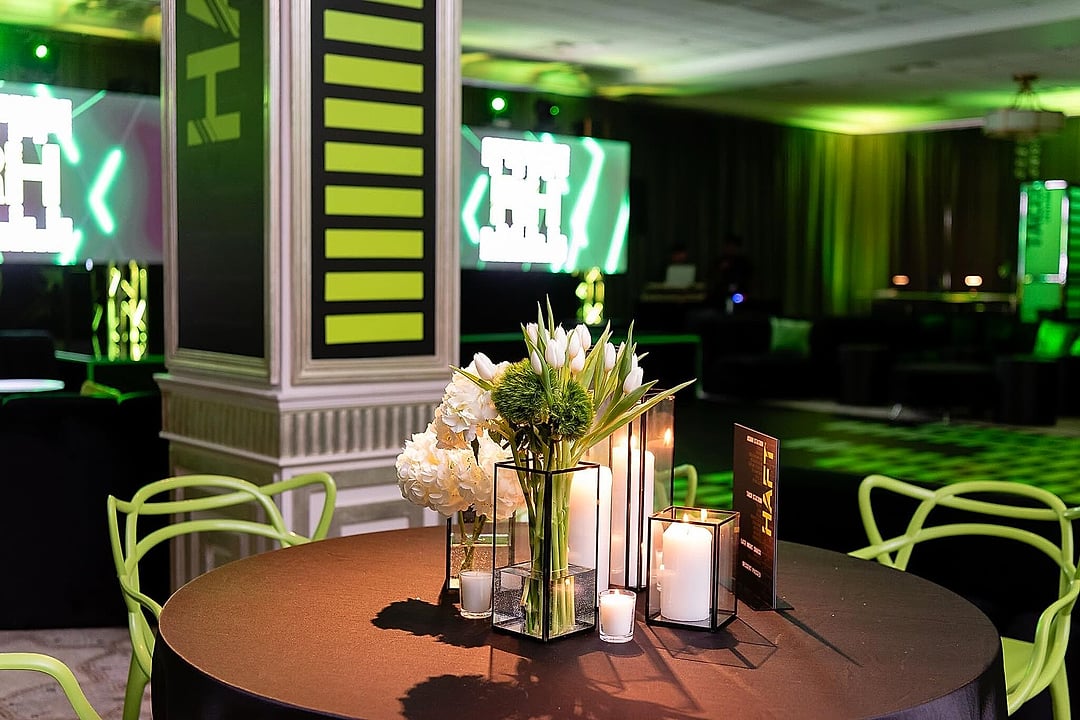 Round black table with white tulips and candles in green light