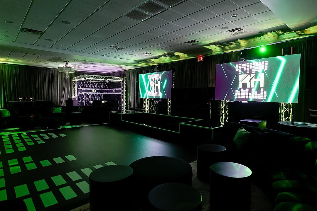 Dark ballroom with LED screens and a glowing patterned dance floor